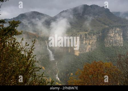 Salt de Sallent Wasserfall von den Tavertet Cliffs aus gesehen an einem nebligen Regentag (Collsacabra, Katalonien, Spanien) ESP: Vistas del Salto de Sallent de Rupit Stockfoto