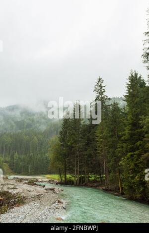 An einem regnerischen Tag rollt im Herbst ein blauer Fluss durch Mittelösterreich. Stockfoto