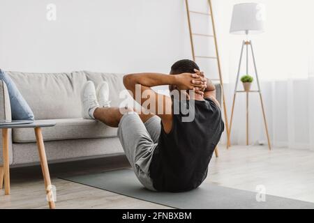 Black Guy Tun Abs Crunches Training Auf Laptop Zu Hause Stockfoto