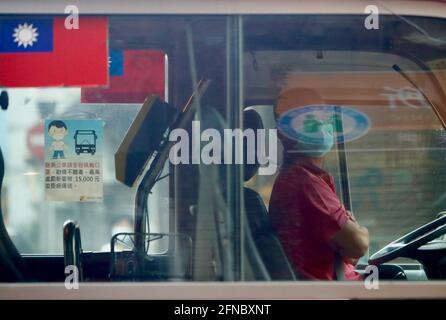 Taipeh, Taiwan. Mai 2021. Ein Busfahrer trägt eine Gesichtsmaske, als Taiwan am Sonntag über 206 Fälle im Inland berichtet, ein Sprung von dem Rekord-Tageshoch am Samstag seit dem Ausbruch der Pandemie. Die Hauptstadt Taipei und New Taipei haben strengere Beschränkungen auferlegt, darunter die Schließung nicht wichtiger Unternehmen und Institute, die Einrichtung von Rapid Covid-Testzentren, die Aussetzung großer Versammlungen und Aktivitäten sowie die Forderung, dass Menschen auf den Straßen eine Maske tragen. Quelle: Daniel Ceng Shou-Yi/ZUMA Wire/Alamy Live News Stockfoto