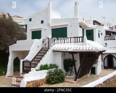 Menorca, Spanien - Juni 23 2006: Typisch spanische, weiß getünchte Strandhäuser nach kykladischer Architektur auf Menorca. Mit Außentreppe. Stockfoto