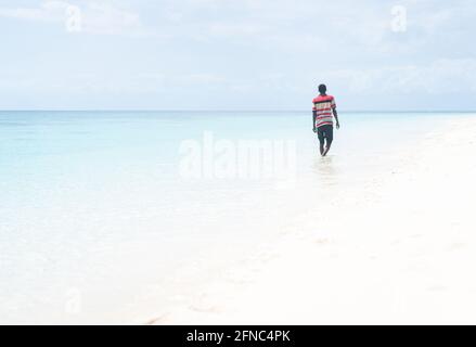 Schwarzer afrikanischer junger Mann, der am Strand läuft Stockfoto
