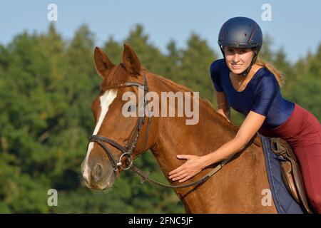 Reiter auf dem Rücken eines bayerischen Kastanienpferdes Stockfoto