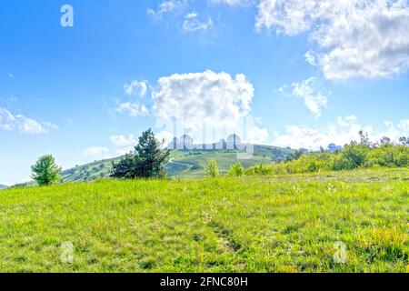 Landschaft mit Hügeln mit grünem Gras bedeckt. Stockfoto