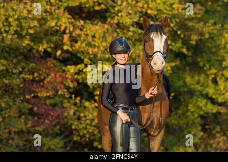 Junger Reiter mit glänzenden Hosen und glänzendem Trikot Herbst Stockfoto