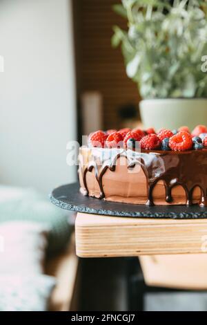 Reicher Schokoladenkuchen mit Himbeeren und einer geschmolzenen Schokolade Darauf Tropfen Stockfoto