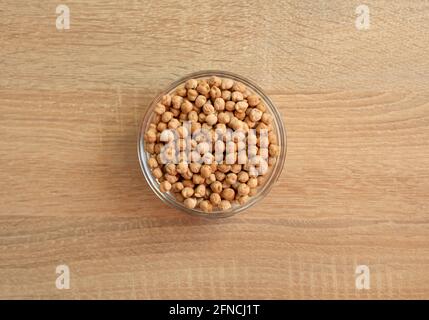 Schüssel mit rohen Kichererbsen auf einem Holztisch Stockfoto