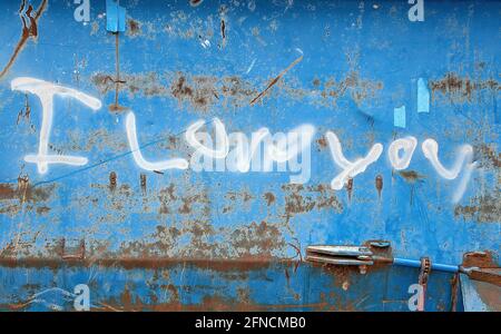 Weiß Ich liebe dich Zeichen Spray auf blauen Müllcontainer gemalt Außen Stockfoto