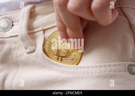 Steckt Bitcoin in der Tasche. Investitionskonzept für Kryptowährungen mit Bitcoin. Stockfoto