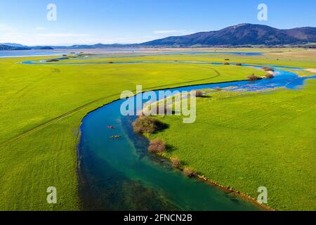 Top Luftaufnahme von zwei Kajaks im Nebenfluss, der in den Cerknica See mündet, schöner Blick über den See und die Berge, aufgenommen mit Drohne, Slowenien Stockfoto