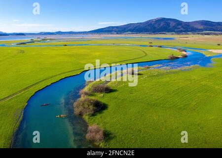 Top Luftaufnahme von zwei Kajaks im Nebenfluss, der in den Cerknica See mündet, schöner Blick über den See und die Berge, aufgenommen mit Drohne, Slowenien Stockfoto