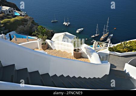 Traditionelle kykladische Steintreppen führen zu einem privaten Segelboothafen auf der Insel Santorini, Kykladen Griechenland. Stockfoto