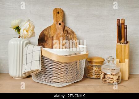 Holzhackbretter in einem weißen Eimer und andere Sachen An der Wand Stockfoto