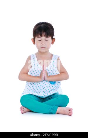 Asiatisches hübsches Kind mit geschlossenen Augen und Yoga-Übungen in Lotus-Pose. Gesundes Mädchen, das im Studio Fitness übt. Isoliert auf weißem Hintergrund. Stockfoto