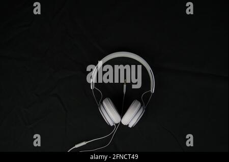 Weiße Studio-Kopfhörer für Podcast-Aufnahmen auf schwarzem Hintergrund. Objekt Stockfoto