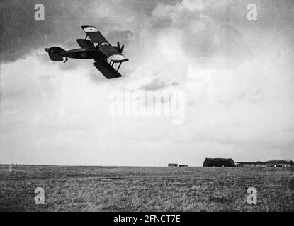 Ein Vintage-Schwarz-Weiß-Foto des Ersten Weltkriegs, das einen britischen Royal Flying Corps Bristol F2B-Kämpfer zeigt, der tief in Richtung eines Flugplatzes fliegt. Stockfoto