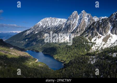 Encantats Twin Peaks und der Estany de Sant Maurici See vom Mirador del Estany aus gesehen, der an einem Frühlingsnachmittag (Aiguestortes, Pyrenäen) aufschlägt Stockfoto