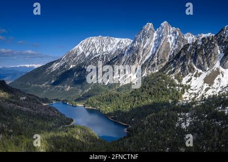 Encantats Twin Peaks und der Estany de Sant Maurici See vom Mirador del Estany aus gesehen, der an einem Frühlingsnachmittag (Aiguestortes, Pyrenäen) aufschlägt Stockfoto