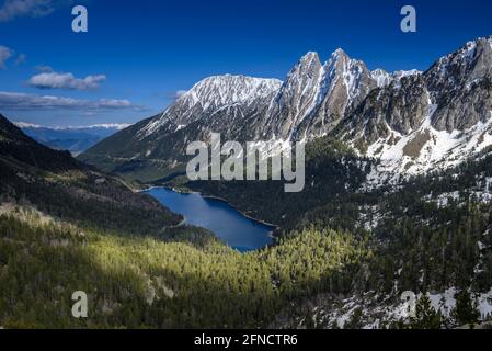 Encantats Twin Peaks und der Estany de Sant Maurici See vom Mirador del Estany aus gesehen, der an einem Frühlingsnachmittag (Aiguestortes, Pyrenäen) aufschlägt Stockfoto