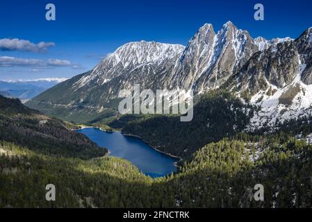 Encantats Twin Peaks und der Estany de Sant Maurici See vom Mirador del Estany aus gesehen, der an einem Frühlingsnachmittag (Aiguestortes, Pyrenäen) aufschlägt Stockfoto