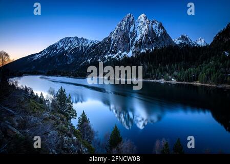 Encantats Twin Peaks vom Estany de Sant Maurici See bei einem Frühlingsaufgang gesehen (Nationalpark Aiguestortes i Sant Maurici, Katalonien, Spanien, Pyrenäen) Stockfoto