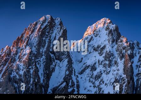 Encantats Twin Peaks vom Estany de Sant Maurici See bei einem Frühlingsaufgang gesehen (Nationalpark Aiguestortes i Sant Maurici, Katalonien, Spanien, Pyrenäen) Stockfoto