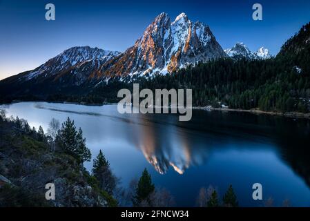 Encantats Twin Peaks vom Estany de Sant Maurici See bei einem Frühlingsaufgang gesehen (Nationalpark Aiguestortes i Sant Maurici, Katalonien, Spanien, Pyrenäen) Stockfoto