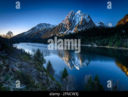 Encantats Twin Peaks vom Estany de Sant Maurici See bei einem Frühlingsaufgang gesehen (Nationalpark Aiguestortes i Sant Maurici, Katalonien, Spanien, Pyrenäen) Stockfoto