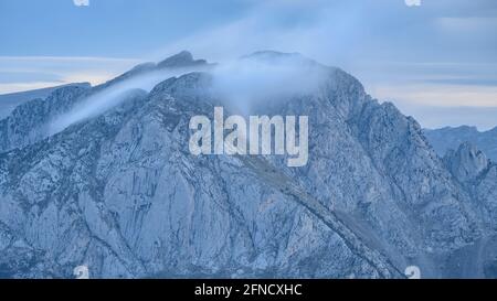 Pedraforca Zwillingsspitzen inmitten Nebel, von der Serra d'Ensija (Berguedà, Katalonien, Spanien, Pyrenäen) gesehen ESP: Los dos picos del Pedraforca entre nieblas Stockfoto