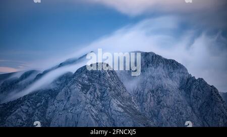 Pedraforca Zwillingsspitzen inmitten Nebel, von der Serra d'Ensija (Berguedà, Katalonien, Spanien, Pyrenäen) gesehen ESP: Los dos picos del Pedraforca entre nieblas Stockfoto