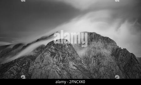 Pedraforca Zwillingsspitzen inmitten Nebel, von der Serra d'Ensija (Berguedà, Katalonien, Spanien, Pyrenäen) gesehen ESP: Los dos picos del Pedraforca entre nieblas Stockfoto