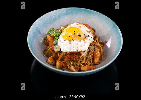 Kalbssteak mit Bohnen und Salat auf schwarzem Hintergrund Stockfoto