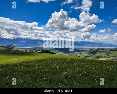 Blick von der Scheidegg oberhalb von Wald auf die Glarner Berge. Gleitschirm in der Luft genießen Sie die Aussicht. Zürich oberland Stockfoto