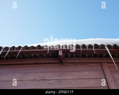 Eiszapfen im Winter. Eis Stalaktit hängt vom Dach des Gebäudes Stockfoto