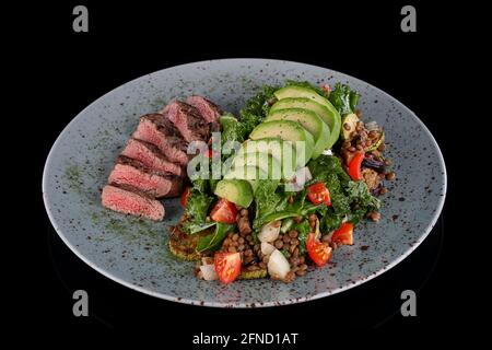 Linsensteak-Salat auf schwarzem Hintergrund Stockfoto