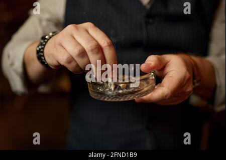 Mann legt eine Zigarette in den Aschenbecher, Nahaufnahme Stockfoto