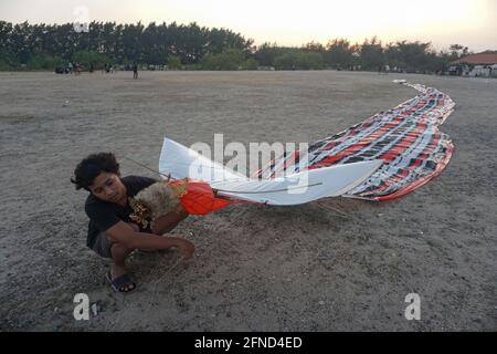 Denpasar, Bali, Indonesien. Mai 2021. Balinesische Jugendliche fliegen Drachen am Mertasari Beach, Sanur. Die Kitesaison findet jedes Jahr zwischen März und September während der Trockenzeit statt und ist die beste Zeit für einen Besuch im Tourismus auf Bali. Die Farben Rot, Weiß, Schwarz und Gold/Gelb repräsentieren die Inkarnationen der balinesischen Hindu-Gottheiten. Kredit: Dicky Bisinglasi/ZUMA Wire/Alamy Live Nachrichten Stockfoto