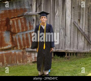 Ein College-Absolvent mittleren Alters posiert mit Abschlusskleidung Stockfoto