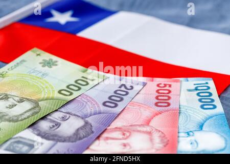Chilenisches Geld auf dem Hintergrund der Farben der Nationalflagge, verschiedene Banknoten, Wirtschafts- und Geschäftskonzept Stockfoto