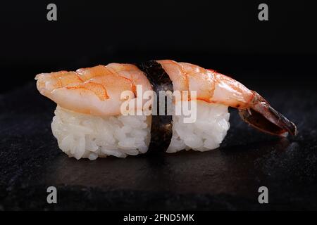 Sushi mit königlichen Garnelen auf schwarzem Hintergrund Stockfoto