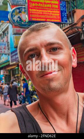 Weltreise Rucksacktouristen in China Town Bangkok, während starker Verkehr. Kannst du jetzt noch in Thailand Rucksack tragen? Stockfoto