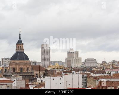 Blick auf Madrids Stadtbild an einem Wintertag, mit der Kirche San Andres im ersten Semester und den Skyscrappern der Plaza de España im Hintergrund. Stockfoto