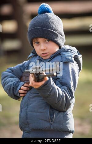 Kleiner Junge zielt auf das Luftgewehr Stockfoto