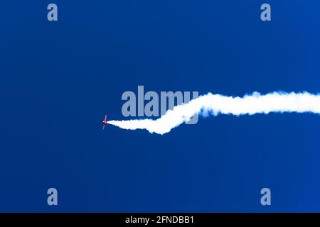 Kunstflug-Flugzeug, das eine Spur von Rauch hinterlässt, während ein Manöver durchgeführt wird Stockfoto