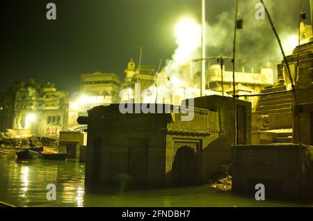 Rauch breitet sich aus Feuer aufgrund der Einäscherung neben dem ganga-Fluss in Varanasi im indischen Bundesstaat Uttar pradesh aus Stockfoto
