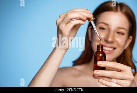 Hautpflege. Schönheitsporträt Der Frau, Die Flasche Mit Dropper In Der Nähe Des Gesichts Hält. Modell Mit Natürlichen Kosmetischen Produkt Für Hydratisiert, Glühend Und Gesund Stockfoto