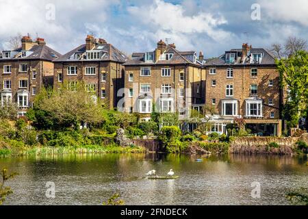 Häuser in Hill Park Gardens mit Blick auf einen Teich in Hampseatd Heath, London, Großbritannien Stockfoto