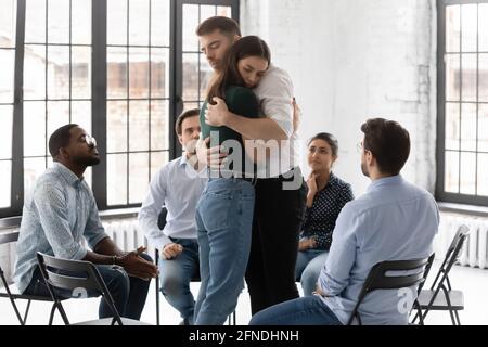 Ein paar Kollegen der Therapiegruppe umarmen sich beim Treffen Stockfoto