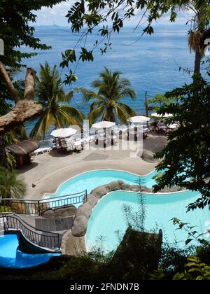 Wunderschöner Blick auf die Pools mit Tischen und Stühlen in einem Resort, das den Pazifik in Eagle Point, Batangas, Lozon, Philippinen überwacht Stockfoto