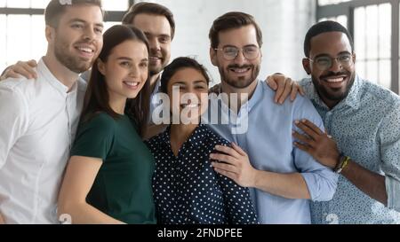 Aufgeregtes Team aus tausenden von Mitarbeitern, das eng beisammen steht Stockfoto
